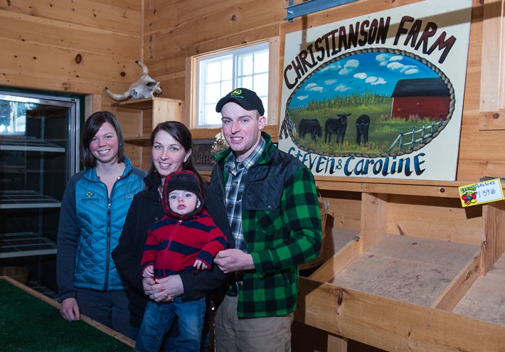 Steven and Caroline Christianson and son Easton stand in their farm stand business with their FarmStart advisor Kathryn Bisson 