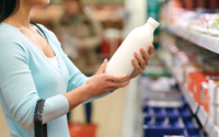 shopper in grocery store looking at milk product