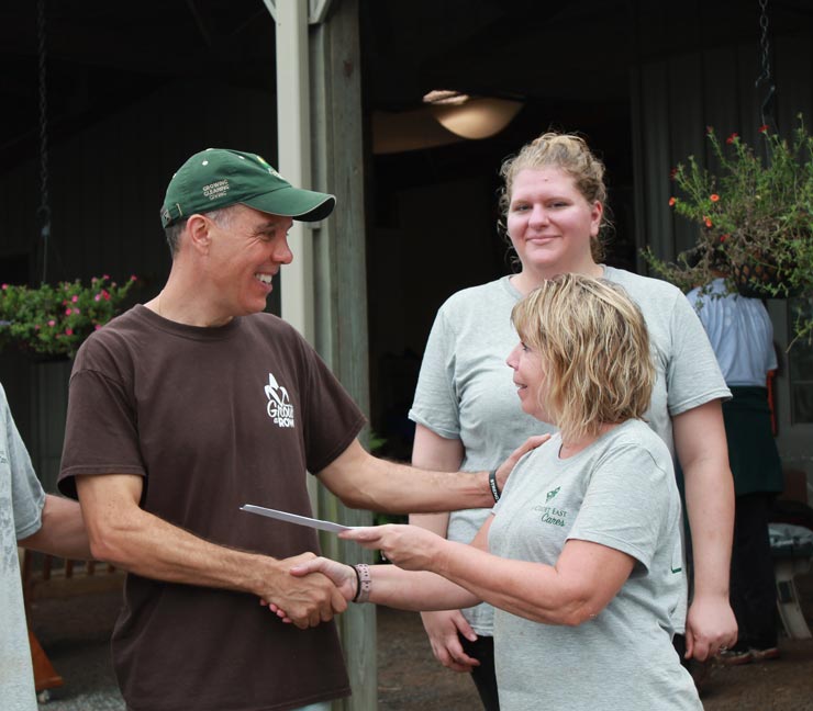 Farm Credit East representative hands a community organization a $1,000 check 