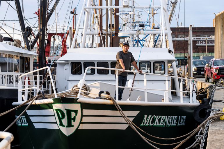 Fisherman Hudson Frye standing on his fishing boat.