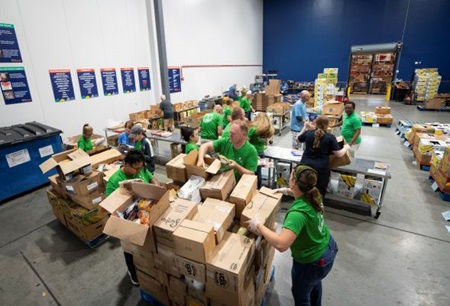 Farm Credit East employees in matching green t-shirts volunteering at a food bank