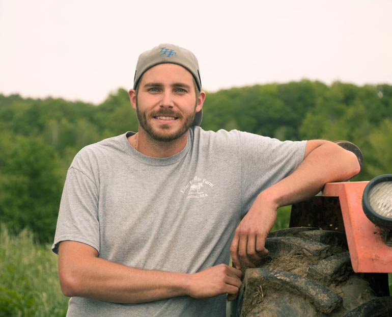 Young pasture-raised livestock farmer smiling at camera 