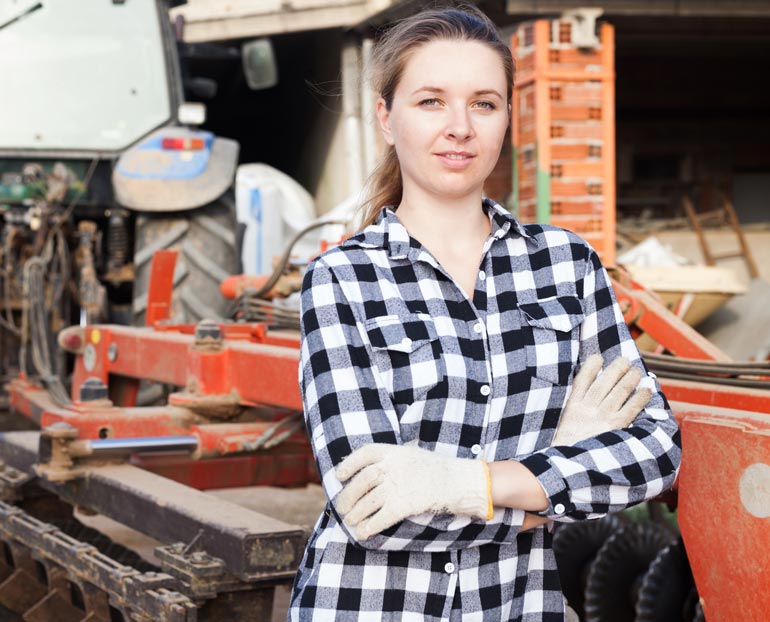 Ag high school senior leans against farm equipment 