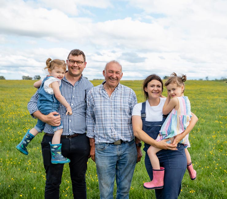 Three generations of family farmers smiling 