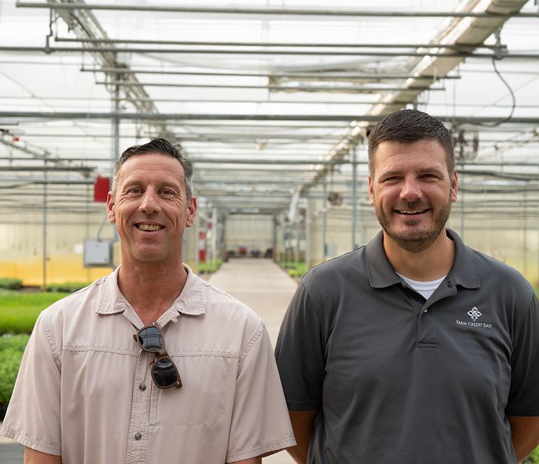 Farm Credit East loan officer in greenhouse with customer