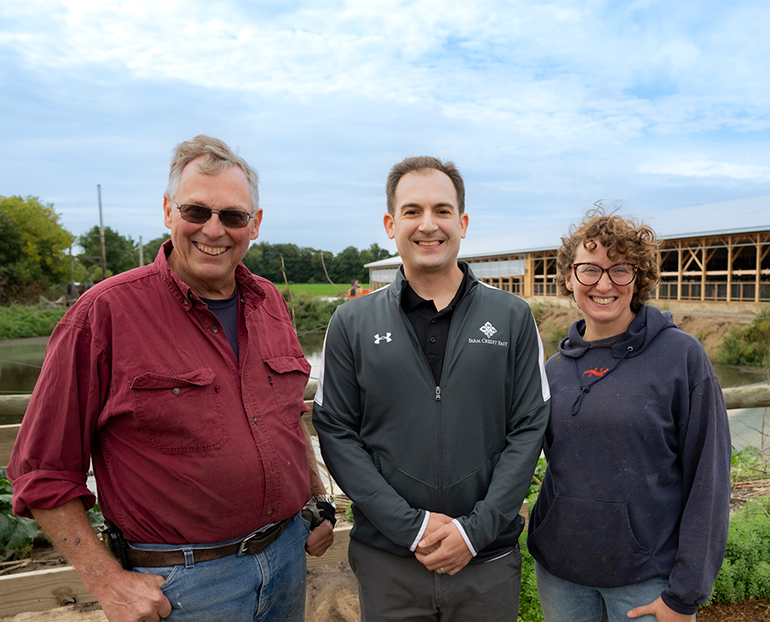 Two men and a woman at a dairy farm