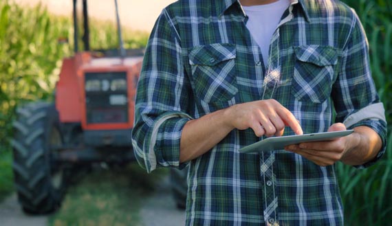 Close-up of farmer in field reviewing data on his tablet 