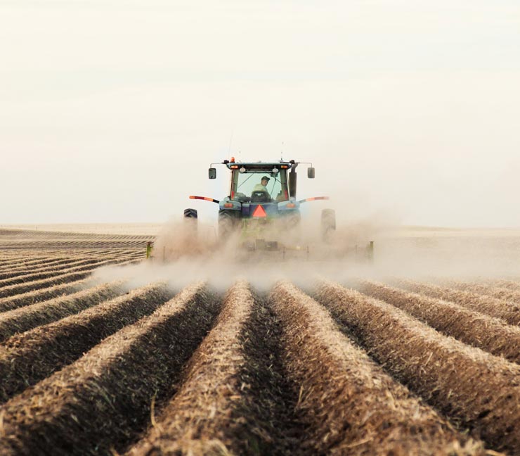 Tractor tilling a New England field 