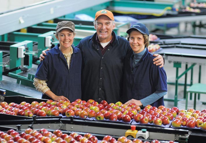 Jennifer, Jeff and Joy Crist of Crist Bros. Orchards posing in their state-of-the-art apple packing facility. 
