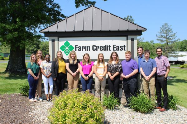 Group picture of 2023 Farm Credit East Interns in front of Farm Credit East building sign in Enfield CT.