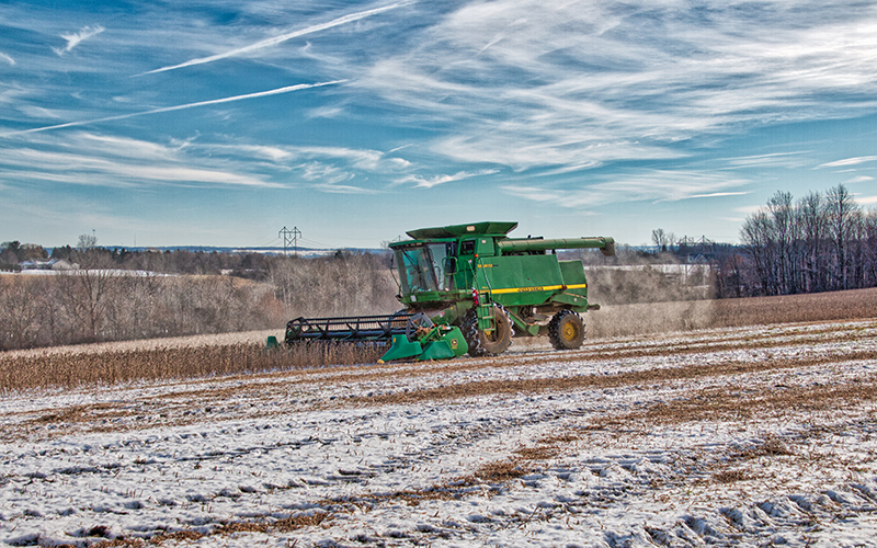 Tractor tilling agricultural field in early spring.