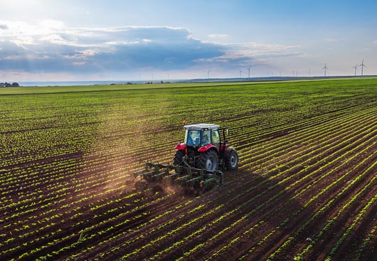 Tractor tilling through a picturesque Northeastern field